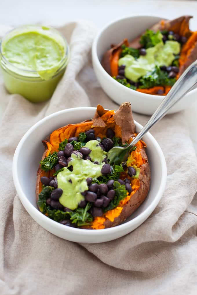 The ultimate vegan loaded sweet potato - packed with kale, black beans, and topped off with a homemade green goddess dressing. Perfect for a quick and easy weeknight meal. Gluten-free, too!