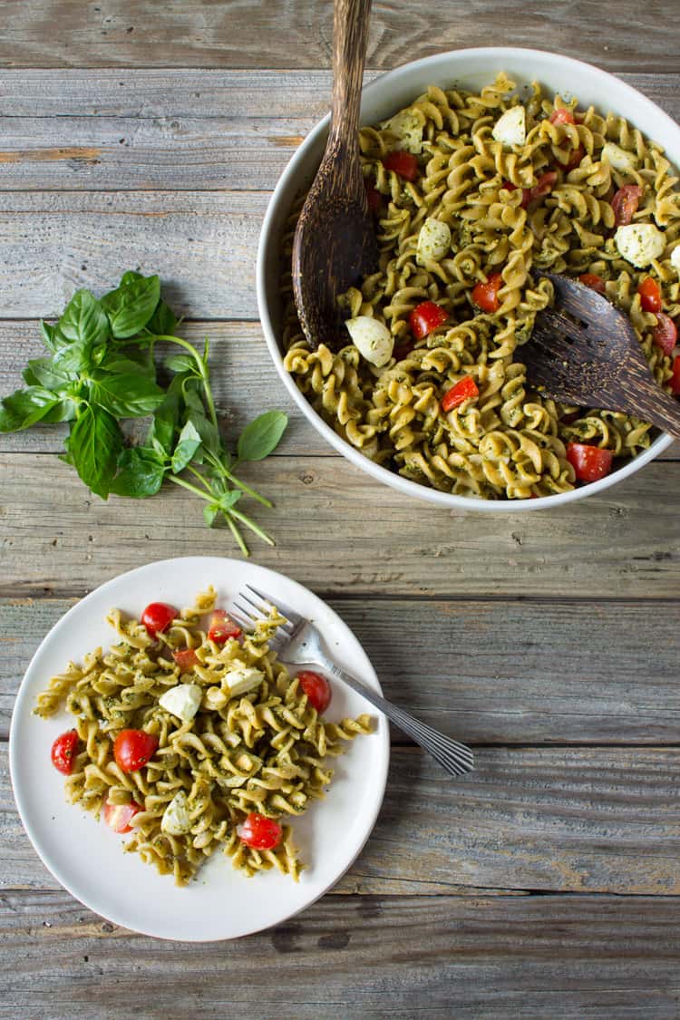 Caprese Hemp Pesto Pasta Salad served on a white plate with basil for garnish