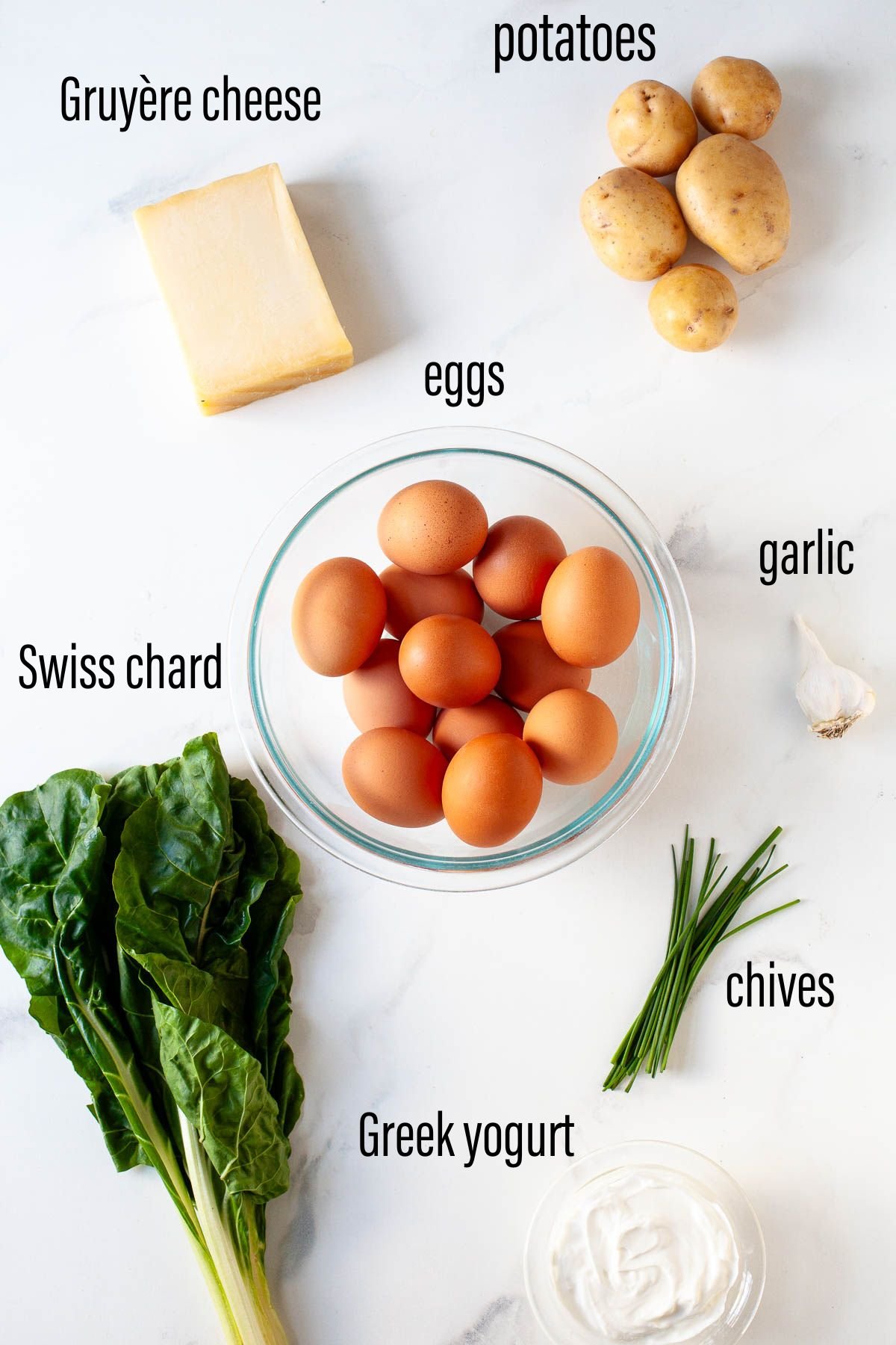 ingredients for swiss chard frittata laid out on marble surface with black text overlay