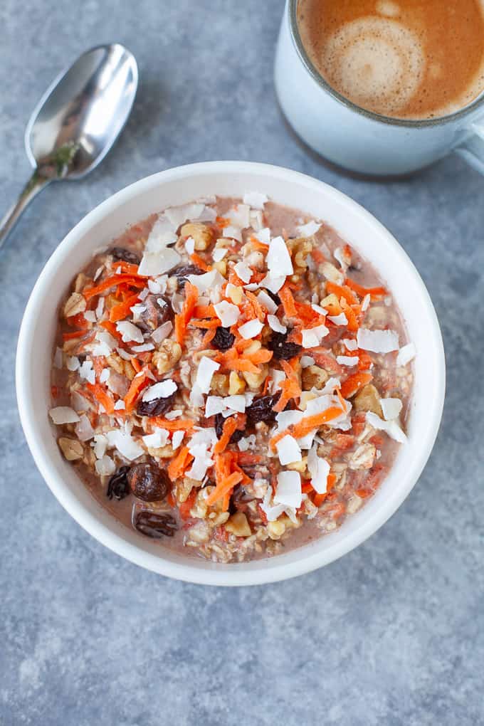 carrot cake overnight oats in a cereal bowl with cup of coffee