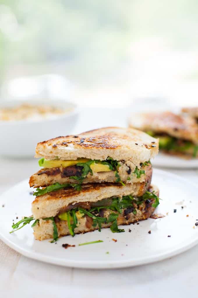 Cauliflower hummus is a new spread that's sure to rock any sandwich - this drool-worthy grilled cauliflower hummus sandwich is packed with avocado, caramelized onion and arugula. Lunch never looked better.