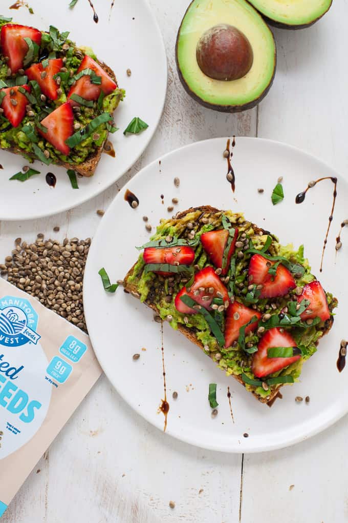 strawberry basil avocado toast, sliced avocado and sunflower seeds on the side