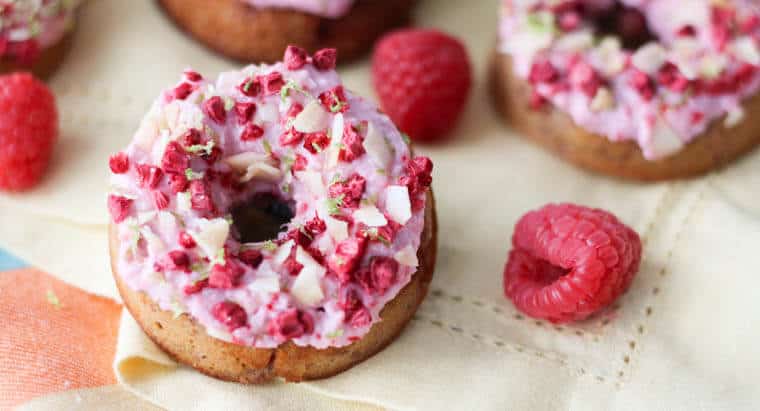 Raspberry margarita gluten free donuts with pink icing and dried raspberries on top