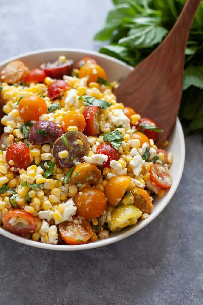 a bowl of corn and tomato salad with caprese