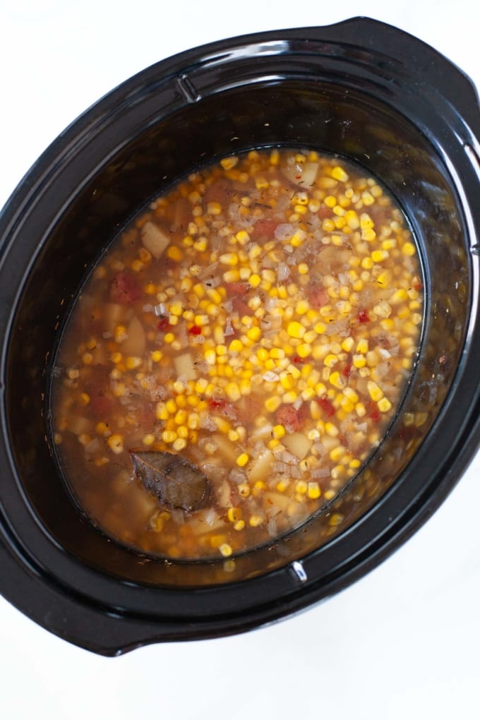 potato, corn, broth, and bay leaf cooked in black slow cooker