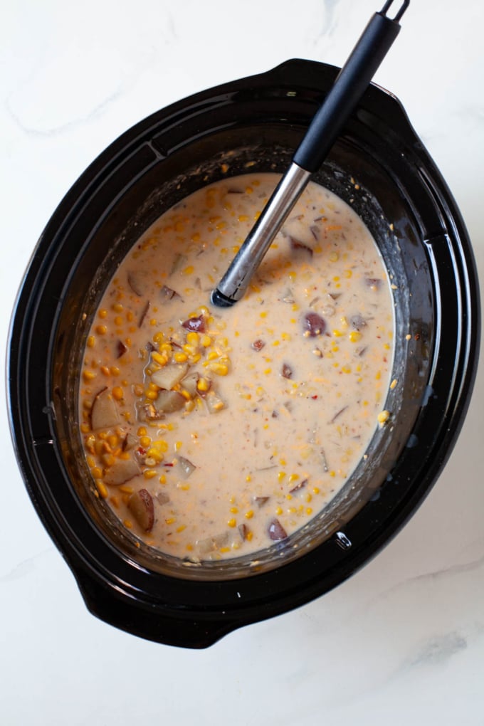 creamy corn potato chowder with greek yogurt in black slow cooker