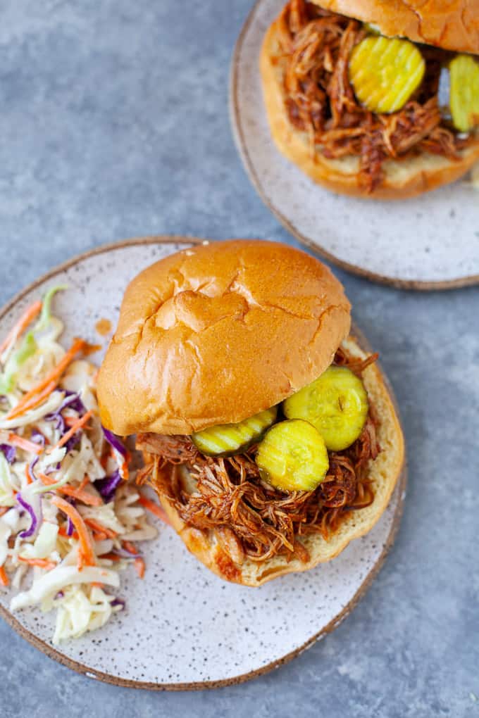 BBQ chicken sandwich with pickles and a side of cole slaw
