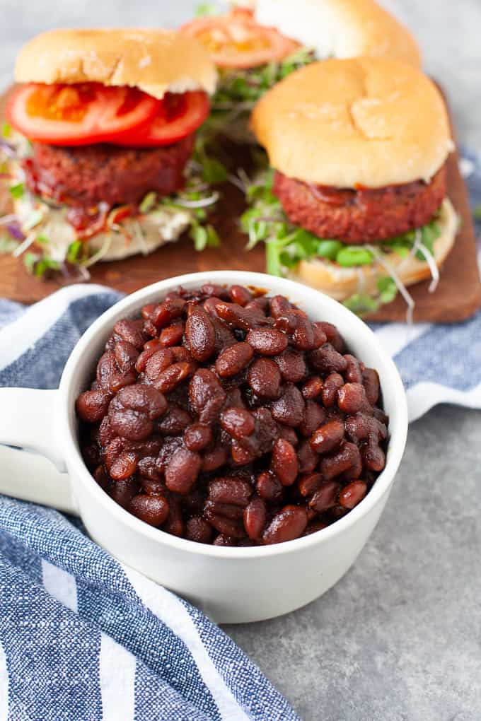 cup of baked beans served with burgers