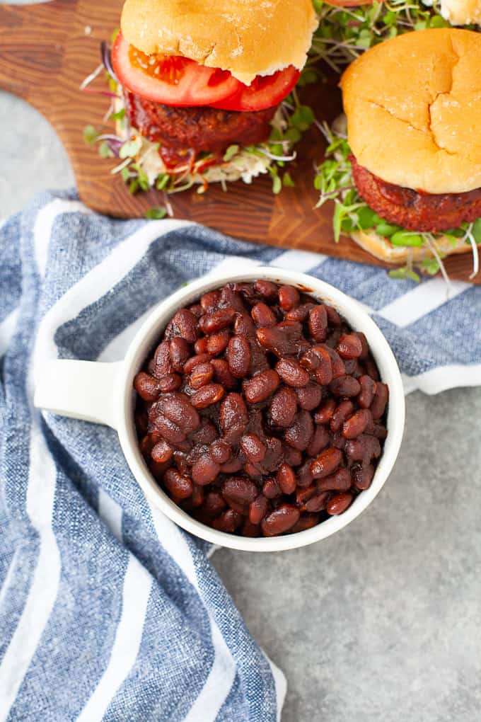 cup of baked beans served with burgers