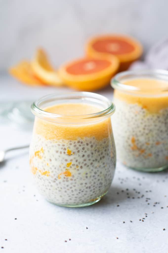 creamsicle chia seed pudding in clear glass jars, orange slices