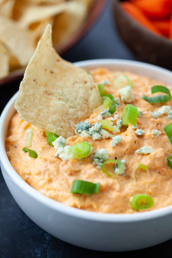 tortilla chip dipped in buffalo cauliflower wing dip