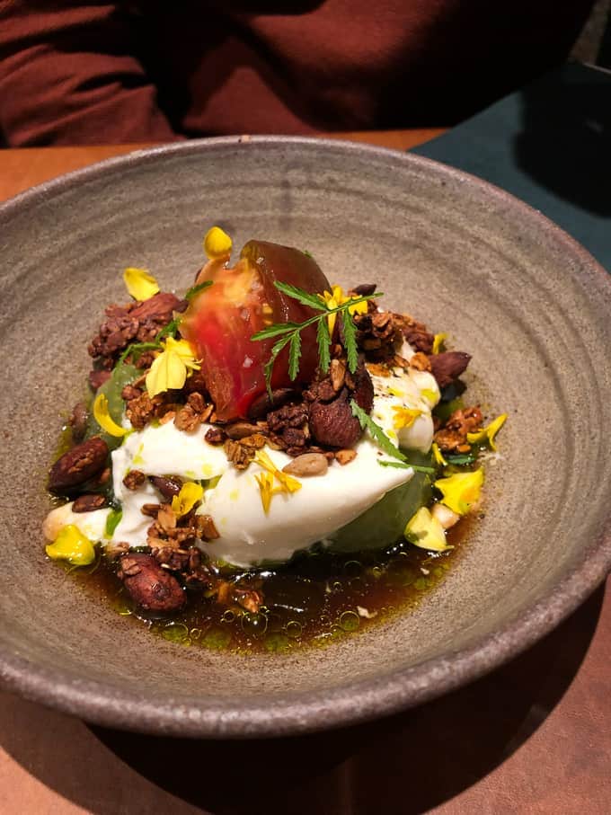 burrata with heirloom tomatoes, granola, and marigold