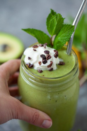 healthy shamrock shake smoothie with whipped topping and cacao garnish