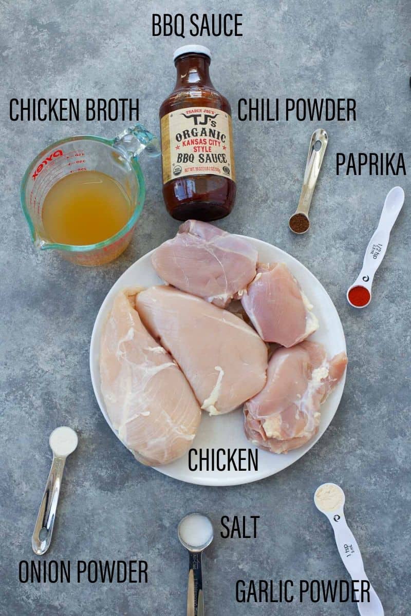 flat lay of ingredients including chicken breasts, a bottle of BBQ sauce, chicken broth, and seasonings