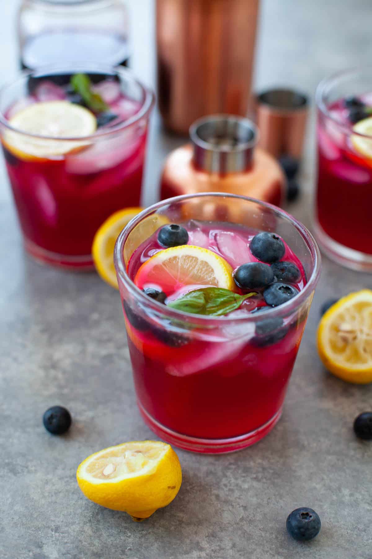 glasses of vodka lemonade with blueberries, a slice of lemon, and ice cubes