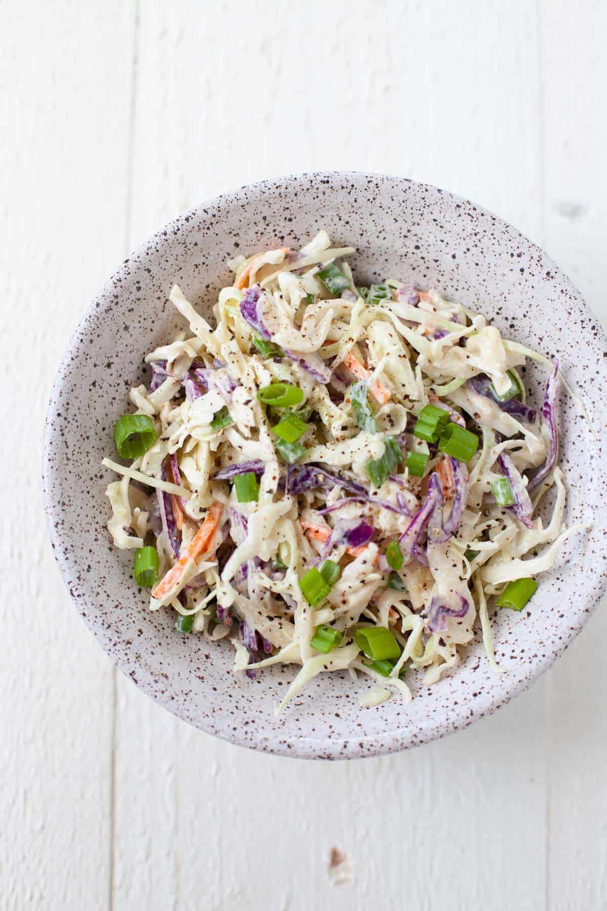bowl of homemade coleslaw with scallions for garnish