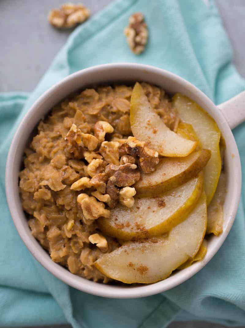 bowl of chai oatmeal with sliced pears and walnuts for garnish