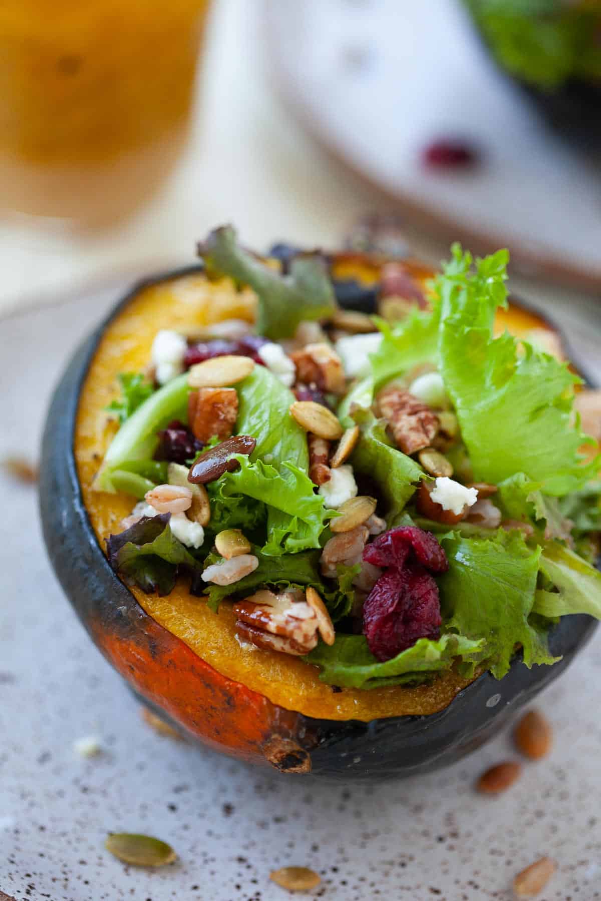 an acorn squash stuffed with baby springs, dried cranberries, goat cheese, pecans, and pepitas