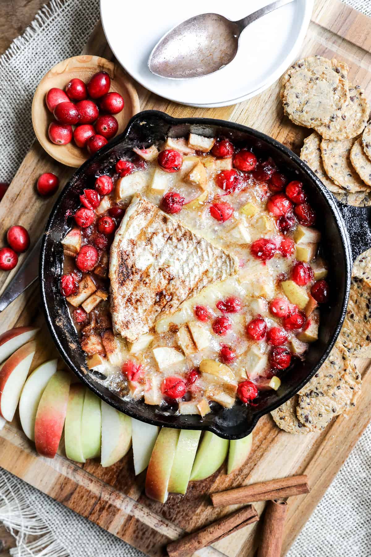 skillet filled with baked brie and cranberries and apples