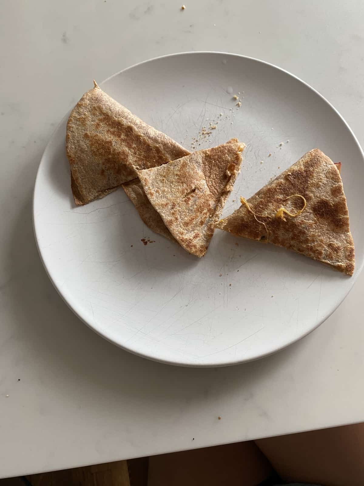 whole wheat cheese and apple quesadilla cut into triangles on white plate