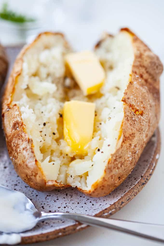 air fried white potato, cut in half, two pats of butter melting