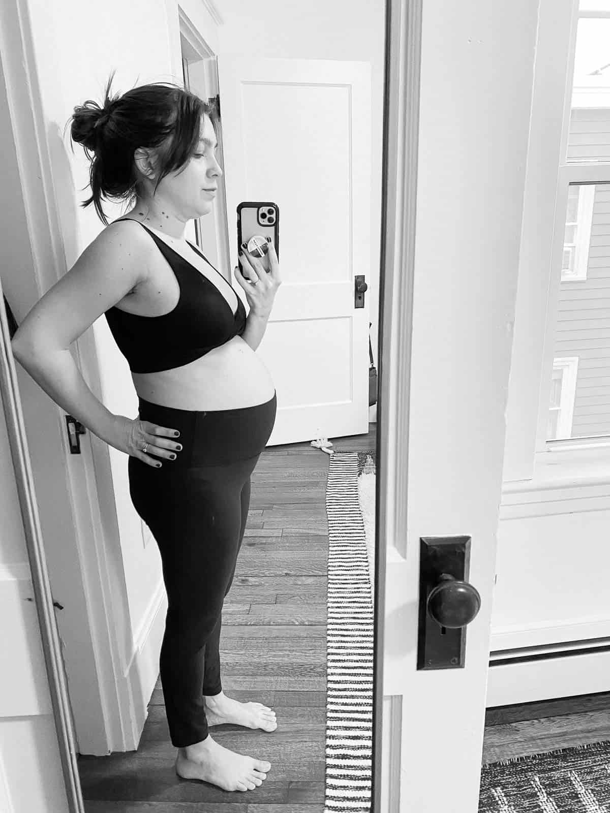kara lydon second trimester pregnancy side profile mirror selfie pregnant journey yoga pants sports bra