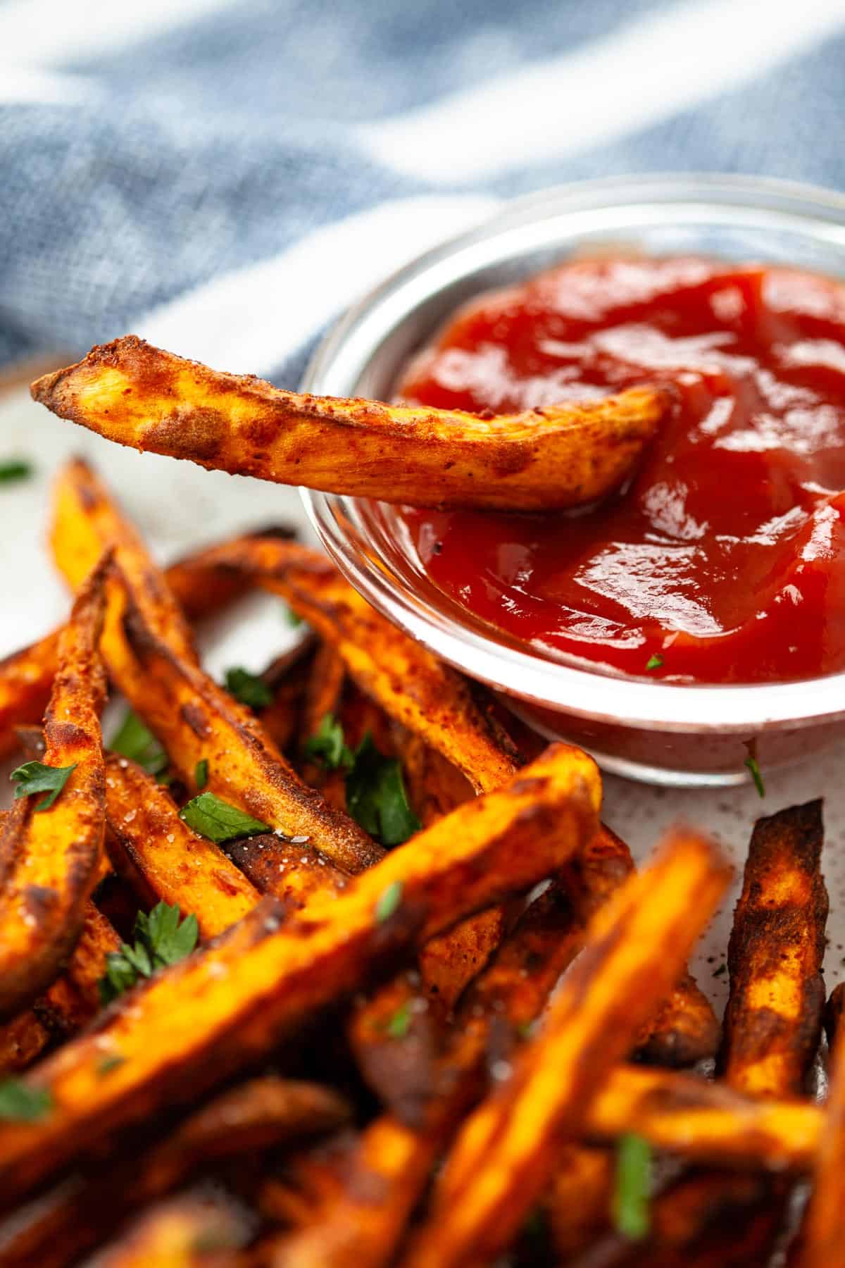 air fryer sweet potato fries dipping fry into side of ketchup dipped fry in ketchup