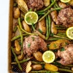 sheet pan chicken potatoes and green beans four marinated chicken thighs, five sliced lemon on pan