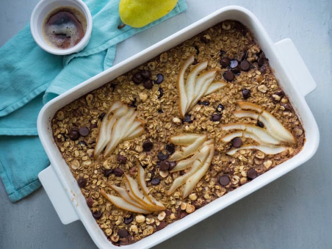 browned butter and pear dark chocolate oatmeal in rectangular baking tray, slices of pear on top and studded with chocolate chips