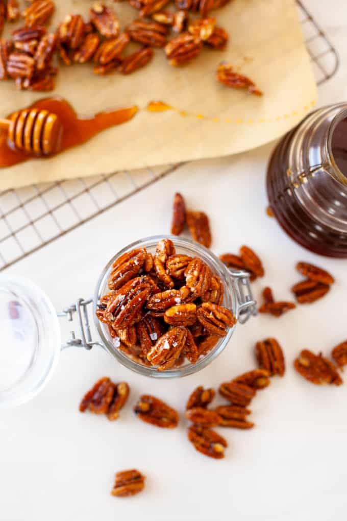 overhead - pecans in jar, scattered on marble table, golden honey comb on parchment paper