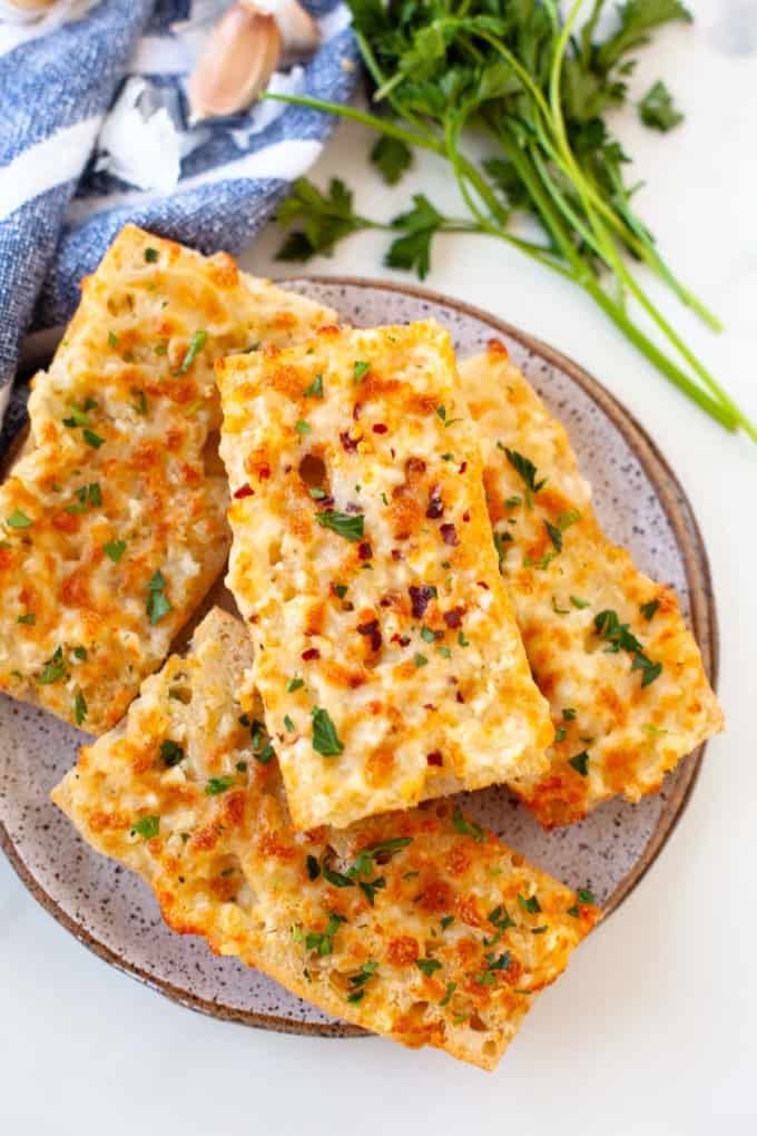 cheesy garlic bread stacked on grey plate