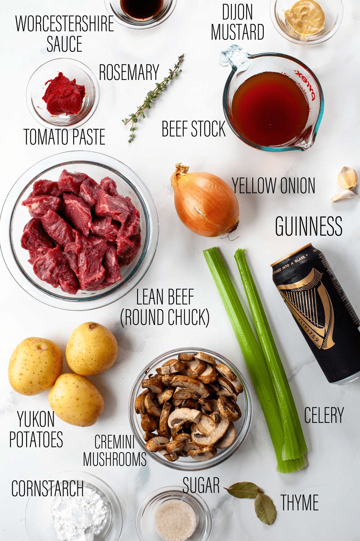 ingredients for instant pot guiness beef stew lay on a white table.