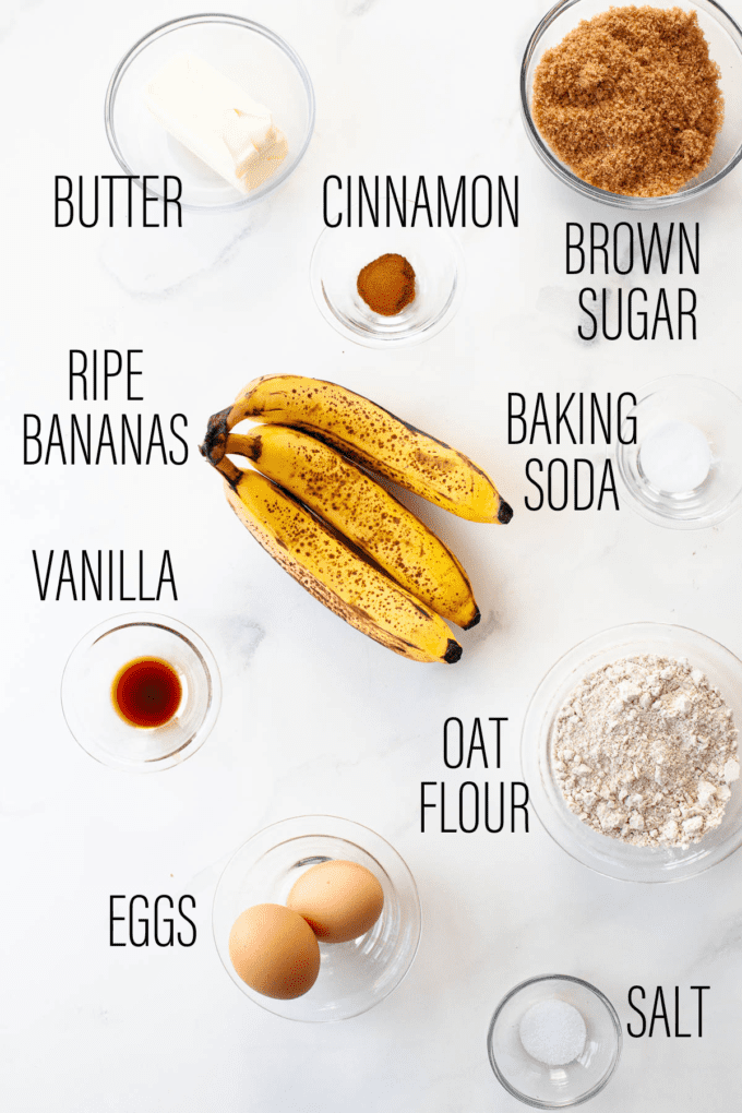 oat flour banana bread ingredients on white marble background