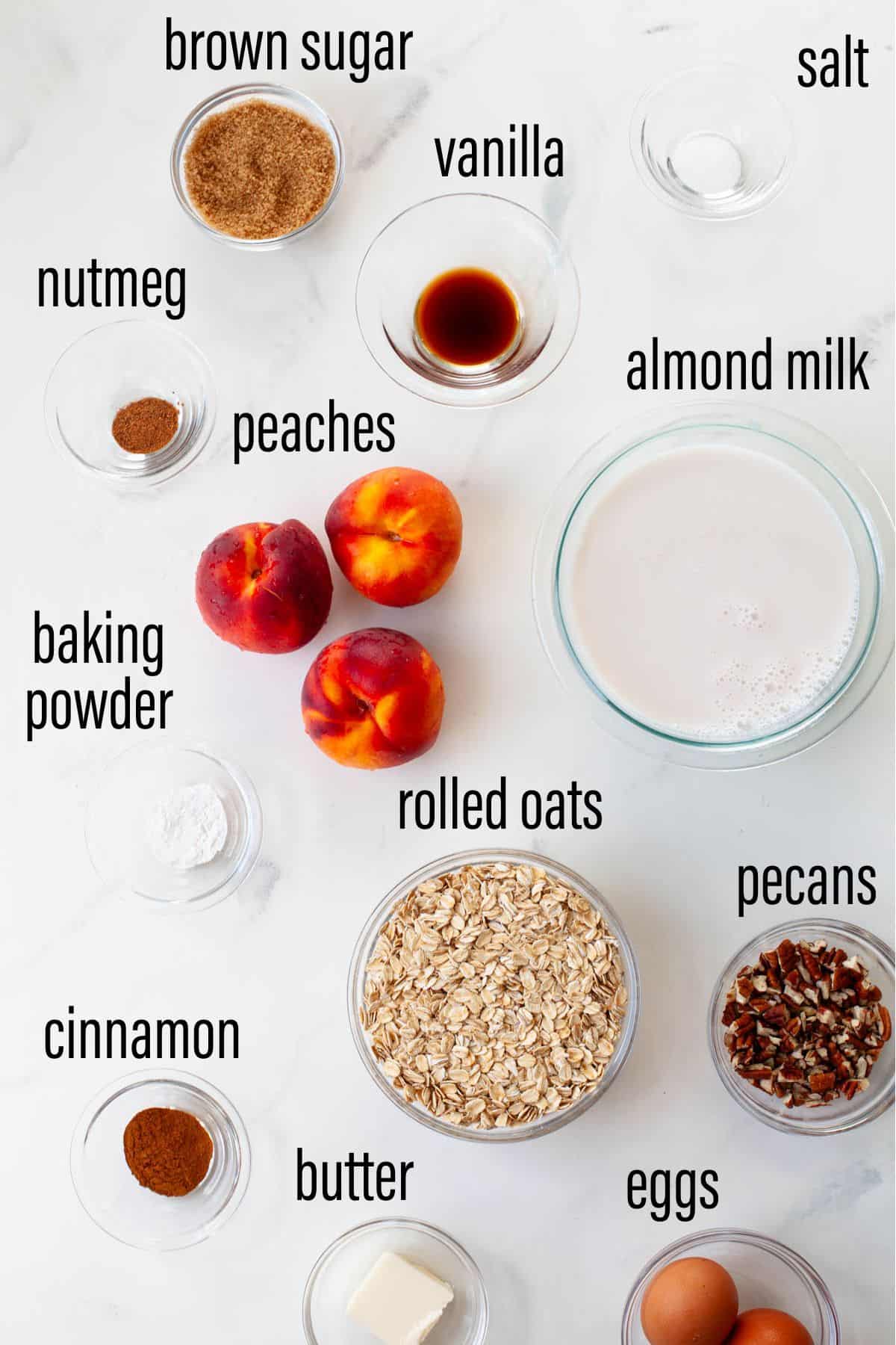 ingredient chart for peach baked oatmeal on marble surface with black text overlay
