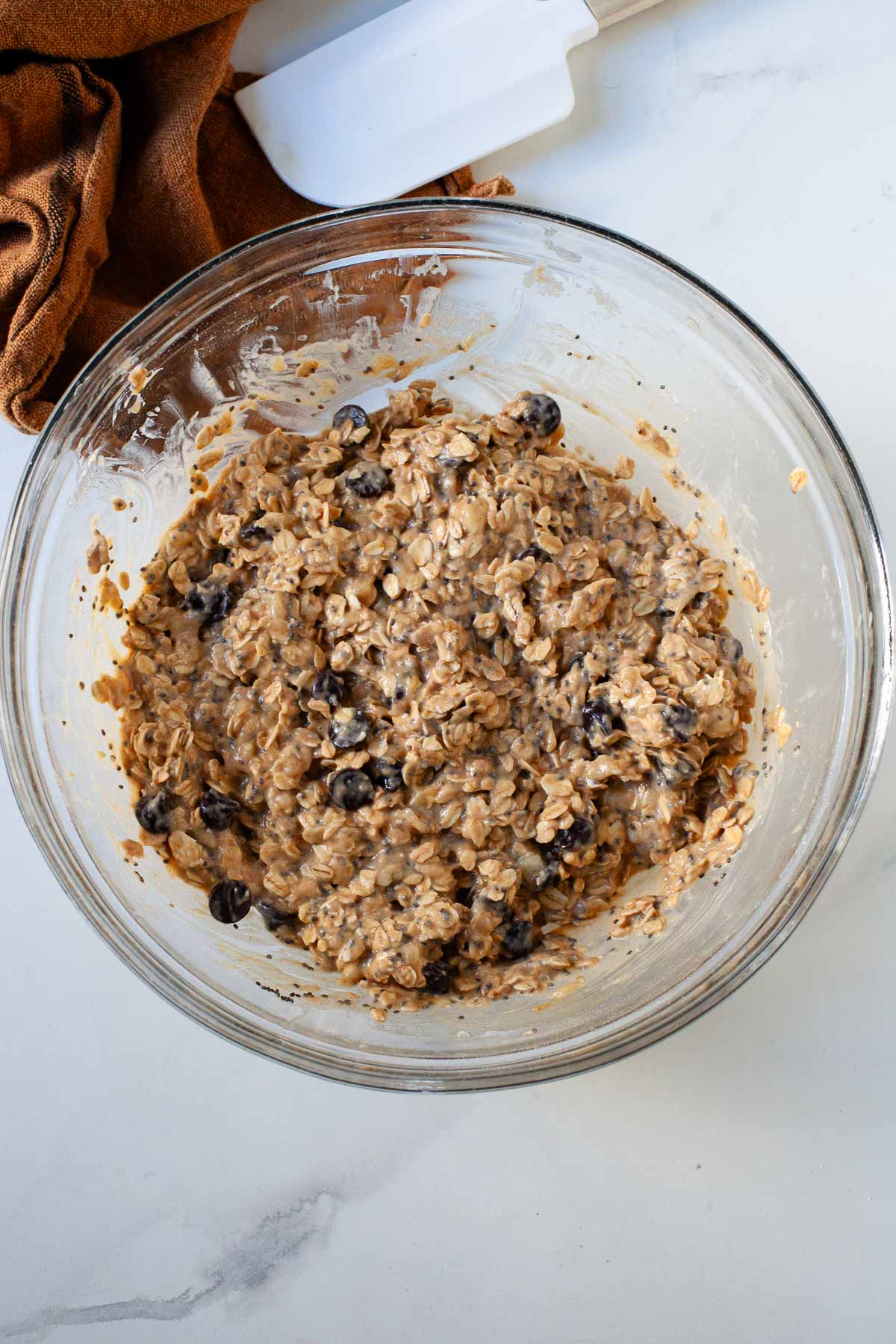 mixture for peanut butter banana oat bars with chocolate chips in glass bowl